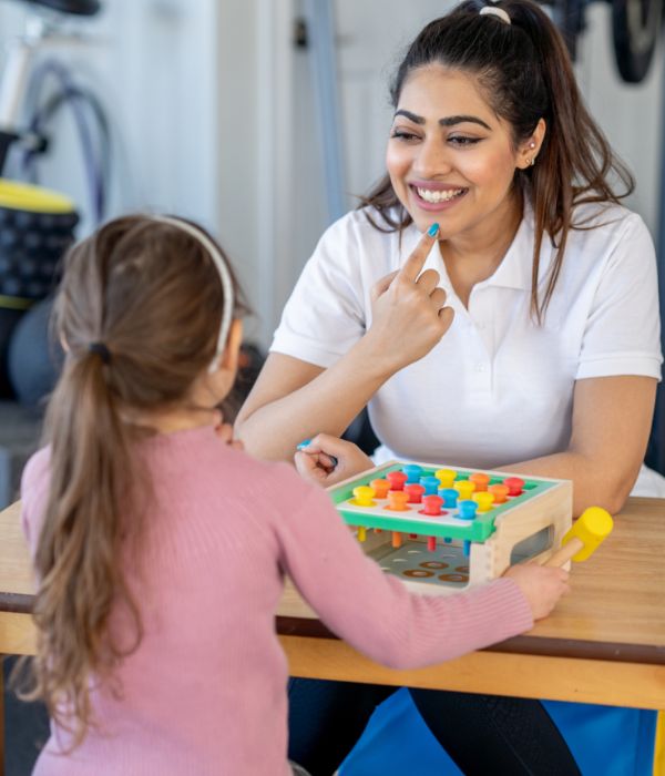 Therapist supporting a child during a learning activity